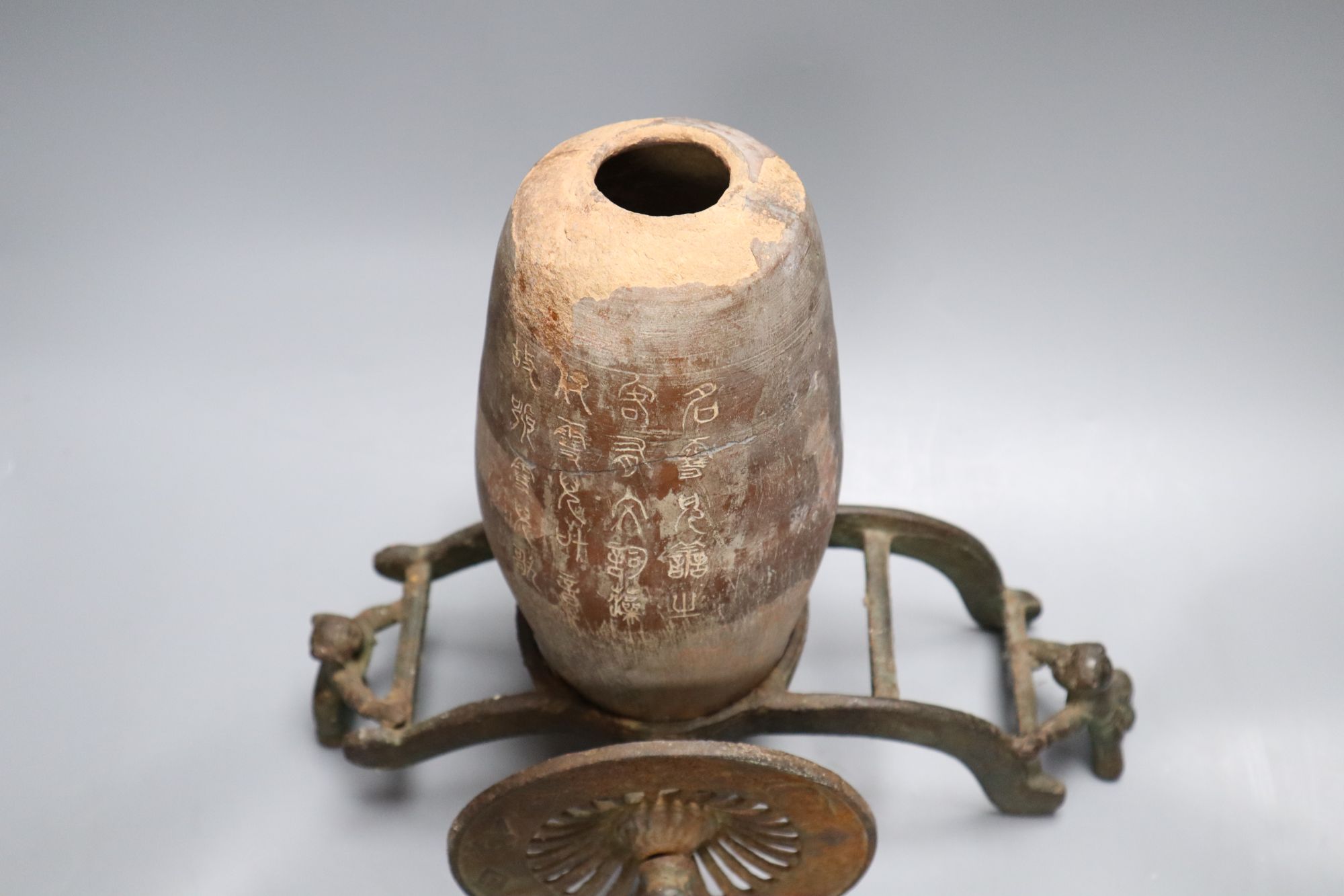 A Chinese pottery vase, with an iron carriage base, Han dynasty or later, height overall 28cm